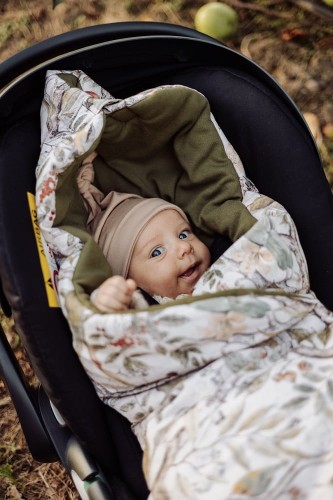 Kocyk do fotelika 100% bawełna z ciepłym wypełnieniem –  Taste of Summer. Zbliżenie na dziecko w foteliku gdy kocyk jest zapięty.